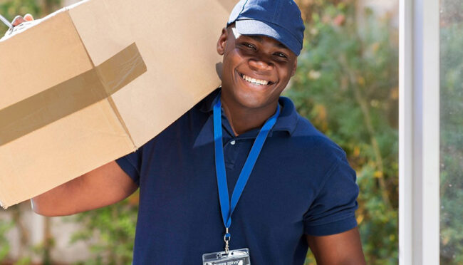 A delivery person with a box on their shoulder.